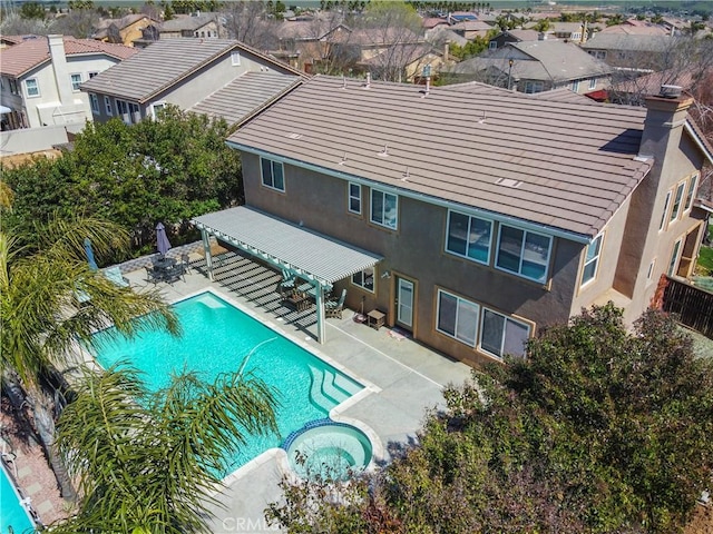 view of pool with a fenced backyard, a residential view, a pool with connected hot tub, and a patio