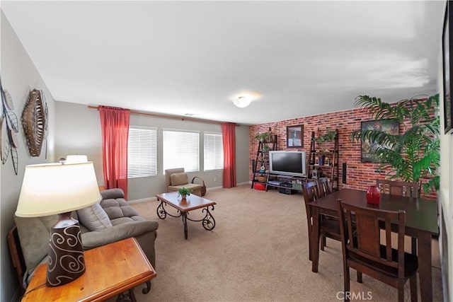 living room featuring carpet floors, baseboards, and brick wall