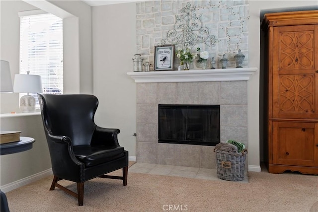 sitting room featuring baseboards, carpet flooring, and a tiled fireplace