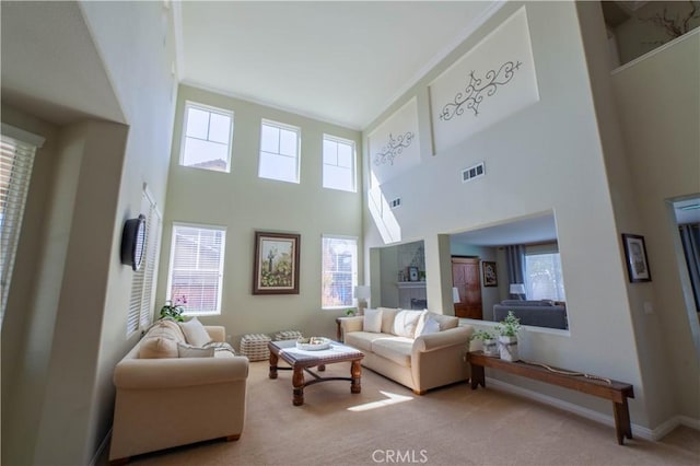 living area with carpet floors, baseboards, and visible vents