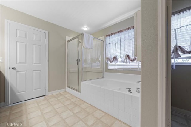 bathroom featuring a garden tub, a stall shower, and plenty of natural light