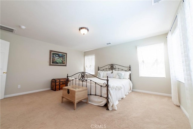 bedroom featuring baseboards, visible vents, and light carpet