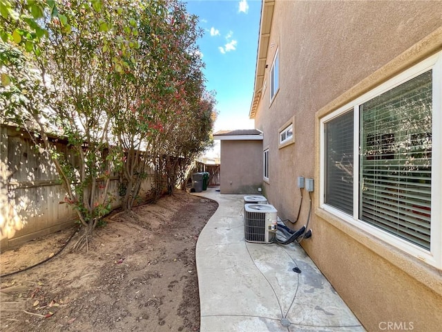 exterior space featuring stucco siding, a patio area, cooling unit, and a fenced backyard