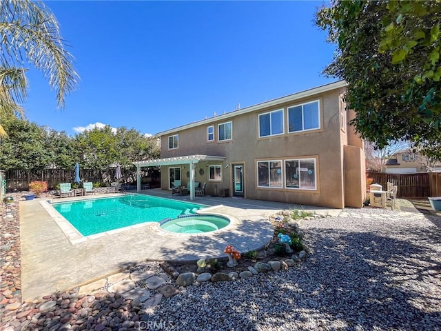 view of pool with a fenced backyard, a pool with connected hot tub, a pergola, and a patio area