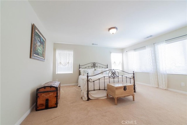 carpeted bedroom featuring baseboards and visible vents