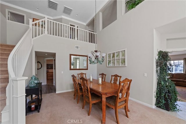 dining room featuring an inviting chandelier, carpet floors, stairway, and visible vents