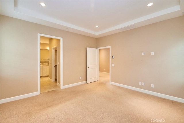 54 Trotter, Irvine, CA 92602 - unfurnished bedroom featuring a tray ceiling, light colored carpet, recessed lighting, and connected bathroom