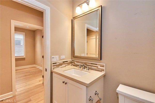 54 Trotter, Irvine, CA 92602 - half bathroom featuring vanity, wood finished floors, and backsplash