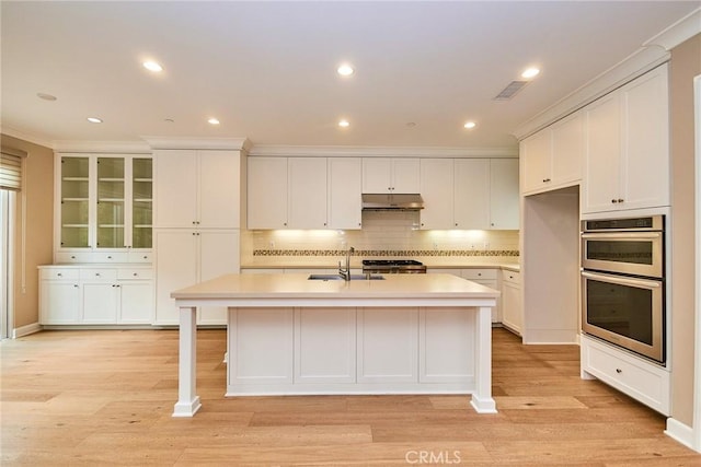 54 Trotter, Irvine, CA 92602 - kitchen with under cabinet range hood, double oven, white cabinetry, and recessed lighting