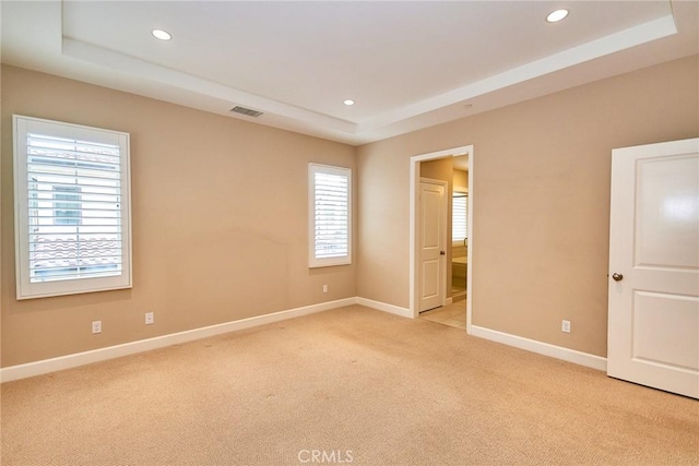 54 Trotter, Irvine, CA 92602 - unfurnished bedroom with a tray ceiling, light carpet, multiple windows, recessed lighting, and ensuite bath