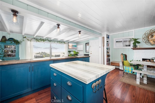 27 A Surfside Ave, Surfside, CA 90743 - kitchen with blue cabinets, a center island, a wood ceiling with exposed beams, dark wood-style flooring, and a brick fireplace