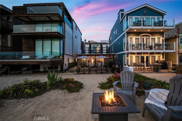 27 A Surfside Ave, Surfside, CA 90743 - back of house at dusk with a fire pit, a patio, and a balcony