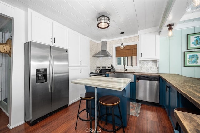 27 A Surfside Ave, Surfside, CA 90743 - kitchen featuring appliances with stainless steel finishes, wall chimney range hood, blue cabinets, and dark wood-style flooring