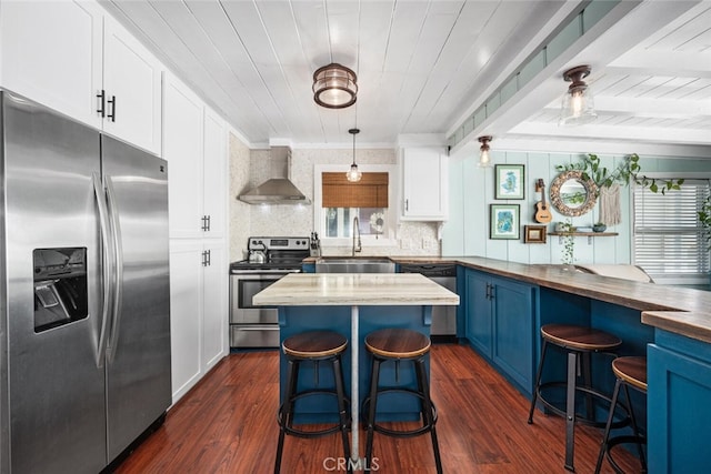 27 A Surfside Ave, Surfside, CA 90743 - kitchen with stainless steel appliances, blue cabinetry, wall chimney range hood, wooden counters, and a kitchen breakfast bar