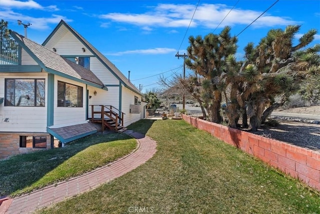 view of side of property with fence and a yard