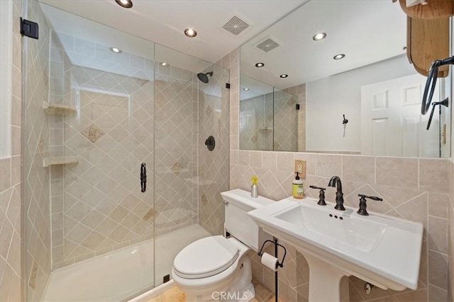 full bathroom with toilet, a stall shower, and visible vents