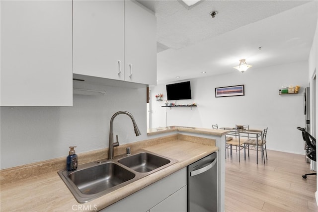 19350 Sherman Way Unit 204, Reseda, CA 91335 - kitchen with stainless steel dishwasher, white cabinets, light countertops, and light wood-type flooring