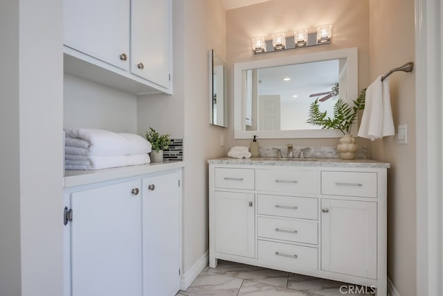 bathroom featuring vanity, baseboards, and marble finish floor