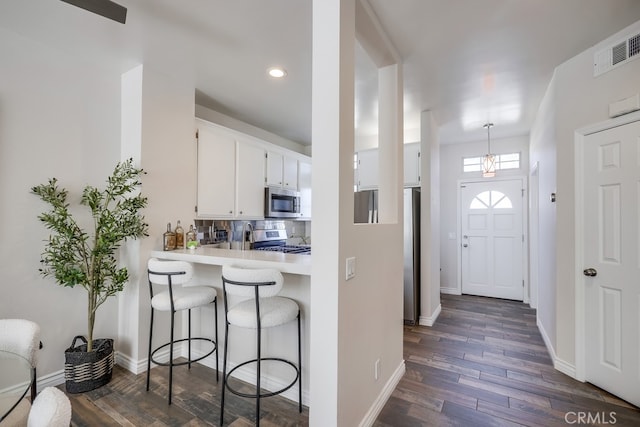entrance foyer featuring recessed lighting, baseboards, dark wood-style floors, and visible vents