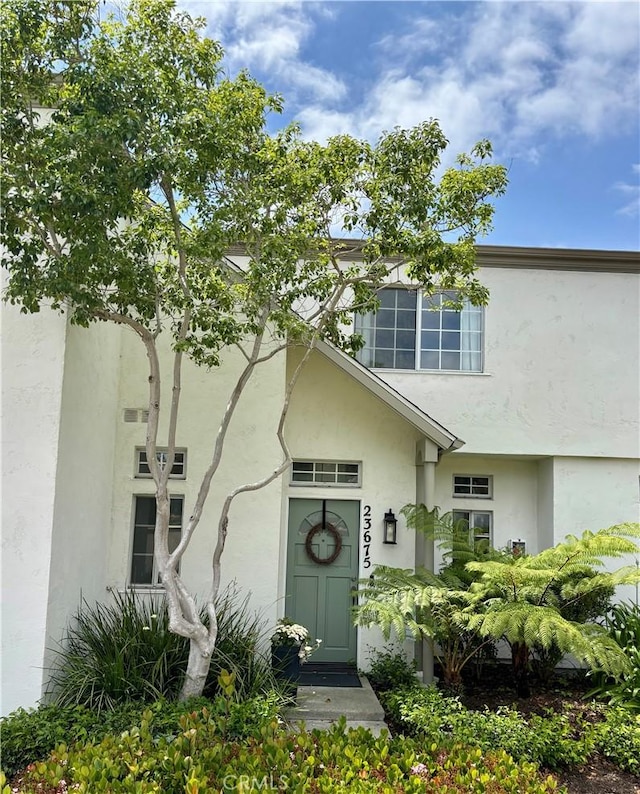entrance to property featuring stucco siding