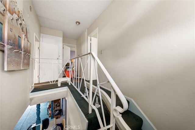 21322 Millpoint Ave, Carson, CA 90745 - staircase featuring a textured ceiling