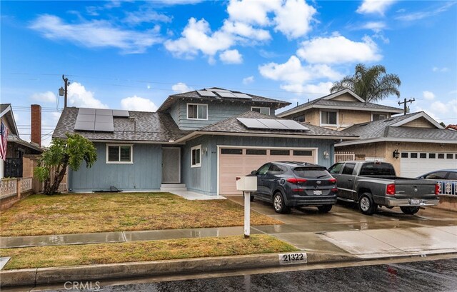 21322 Millpoint Ave, Carson, CA 90745 - view of front of property featuring driveway, a front yard, solar panels, a garage, and a shingled roof