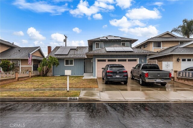 21322 Millpoint Ave, Carson, CA 90745 - view of front facade featuring concrete driveway, fence, an attached garage, a front lawn, and roof mounted solar panels