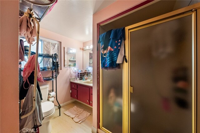 21322 Millpoint Ave, Carson, CA 90745 - bathroom with vanity, toilet, baseboards, a stall shower, and wood finished floors