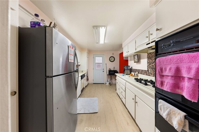 21322 Millpoint Ave, Carson, CA 90745 - kitchen with freestanding refrigerator, white cabinets, black oven, and white gas cooktop