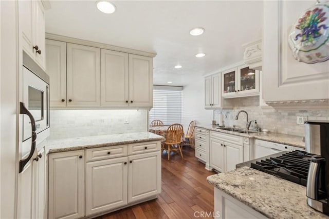 2545 Via Campesina Unit 303, Palos Verdes Estates, CA 90274 - kitchen with a sink, decorative backsplash, dark wood-style floors, recessed lighting, and light stone counters