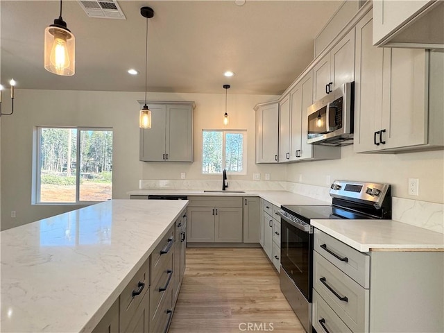 6296 Chatham Ct, Magalia, CA 95954 - kitchen with visible vents, gray cabinets, a sink, light wood-style flooring, and appliances with stainless steel finishes