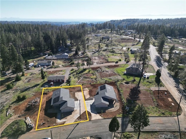 birds eye view of property featuring a forest view
