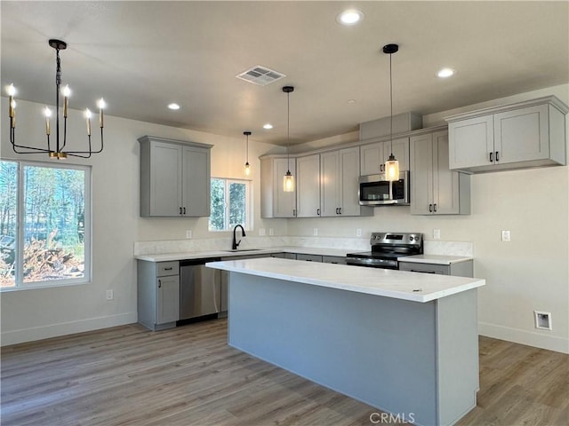 kitchen with stainless steel appliances, baseboards, visible vents, and gray cabinets