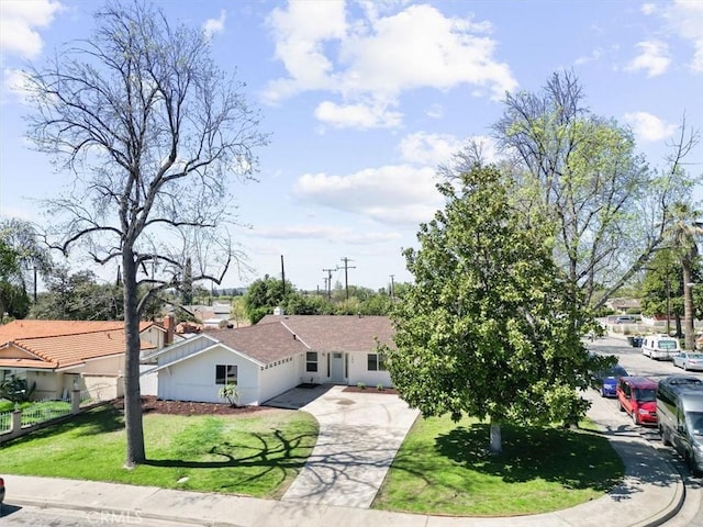 view of front facade featuring driveway, a front yard, and stucco siding