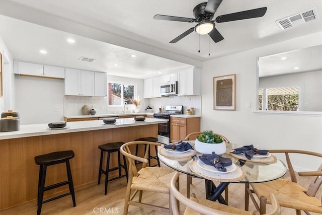 interior space with recessed lighting, light wood-style floors, ceiling fan, and visible vents