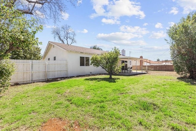 back of property with stucco siding, a fenced backyard, and a yard