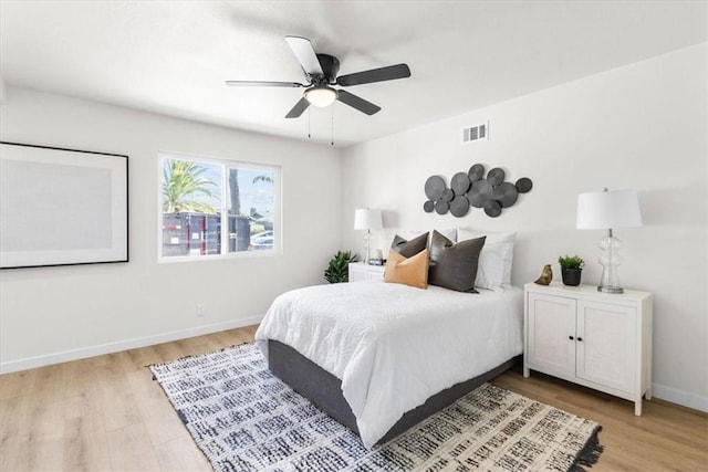 bedroom with baseboards, visible vents, light wood-style floors, and ceiling fan