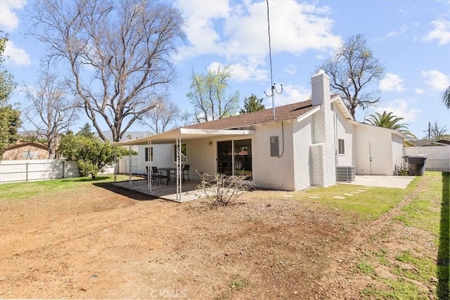 back of house with a patio, a chimney, a fenced backyard, and stucco siding