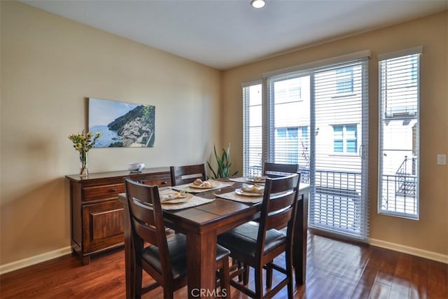 dining space with baseboards and dark wood-style flooring