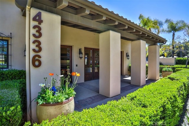 doorway to property featuring french doors and stucco siding