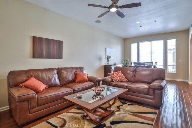 living room featuring a ceiling fan, recessed lighting, baseboards, and wood finished floors