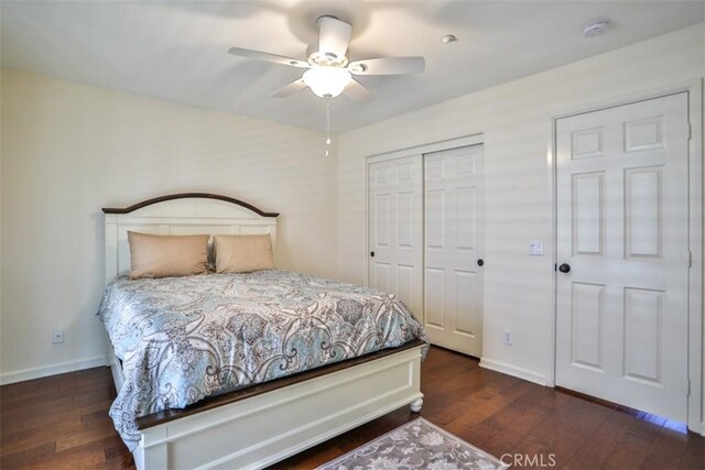 bedroom featuring baseboards, a closet, wood finished floors, and ceiling fan
