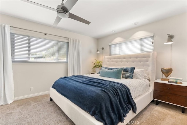 carpeted bedroom featuring ceiling fan, baseboards, and multiple windows