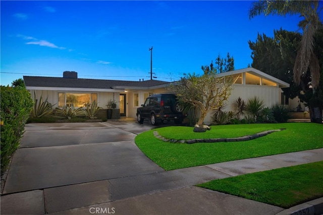 view of front of home featuring driveway and a front lawn