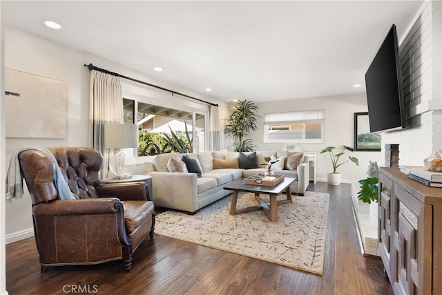 living room with a fireplace, dark wood finished floors, baseboards, and recessed lighting