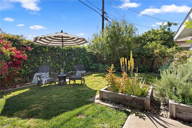 view of yard featuring fence and a vegetable garden