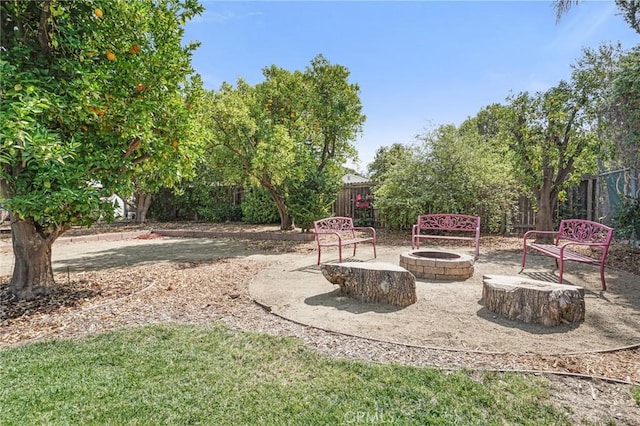 view of yard with fence and an outdoor fire pit