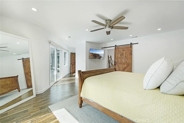 bedroom featuring a barn door, recessed lighting, wood finished floors, visible vents, and ceiling fan