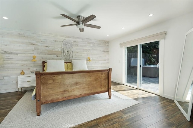 bedroom with recessed lighting, multiple windows, wood finished floors, and access to outside