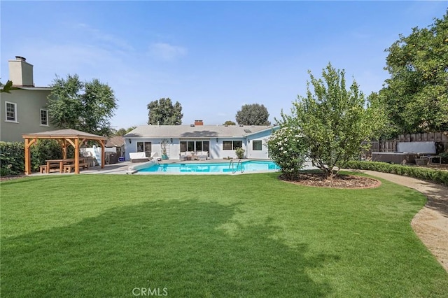 rear view of property featuring a patio area, a fenced in pool, a gazebo, and a yard